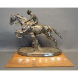 A Large Silver Plated Model in the form of a horse and jockey jumping a fence upon oak plinth,