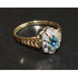 A 9 Carat Gold Aquamarine and Diamond Ring set with an oval aquamarine and surrounded by diamonds