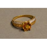 A 9 Carat Gold Citrine Diamond Set Ring with a large citrine flanked by bands of diamonds