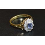 An 18 Carat Gold Tanzanite and Diamond Ring set with an oval tanzanite surrounded by diamonds