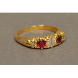 An 18 Carat Yellow Gold Diamond and Ruby Ring set with three diamonds and two rubies in a pierced