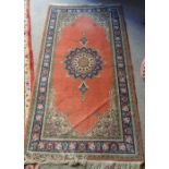 A North West Persian Style Woollen Rug with a central medallion upon a terracotta and blue ground