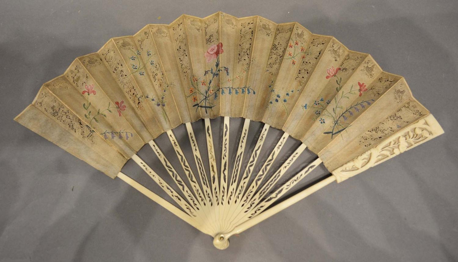 A Mid 18th Century English Fan, the pierced leaf with foliate painting, with carved sticks and