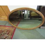 BEVEL EDGED WALL MIRROR; Of oval form in gilded frame with reeded decoration