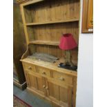 PINE DRESSER, a waxed pine cupboard and drawer base dresser with open plate rack, 49" width