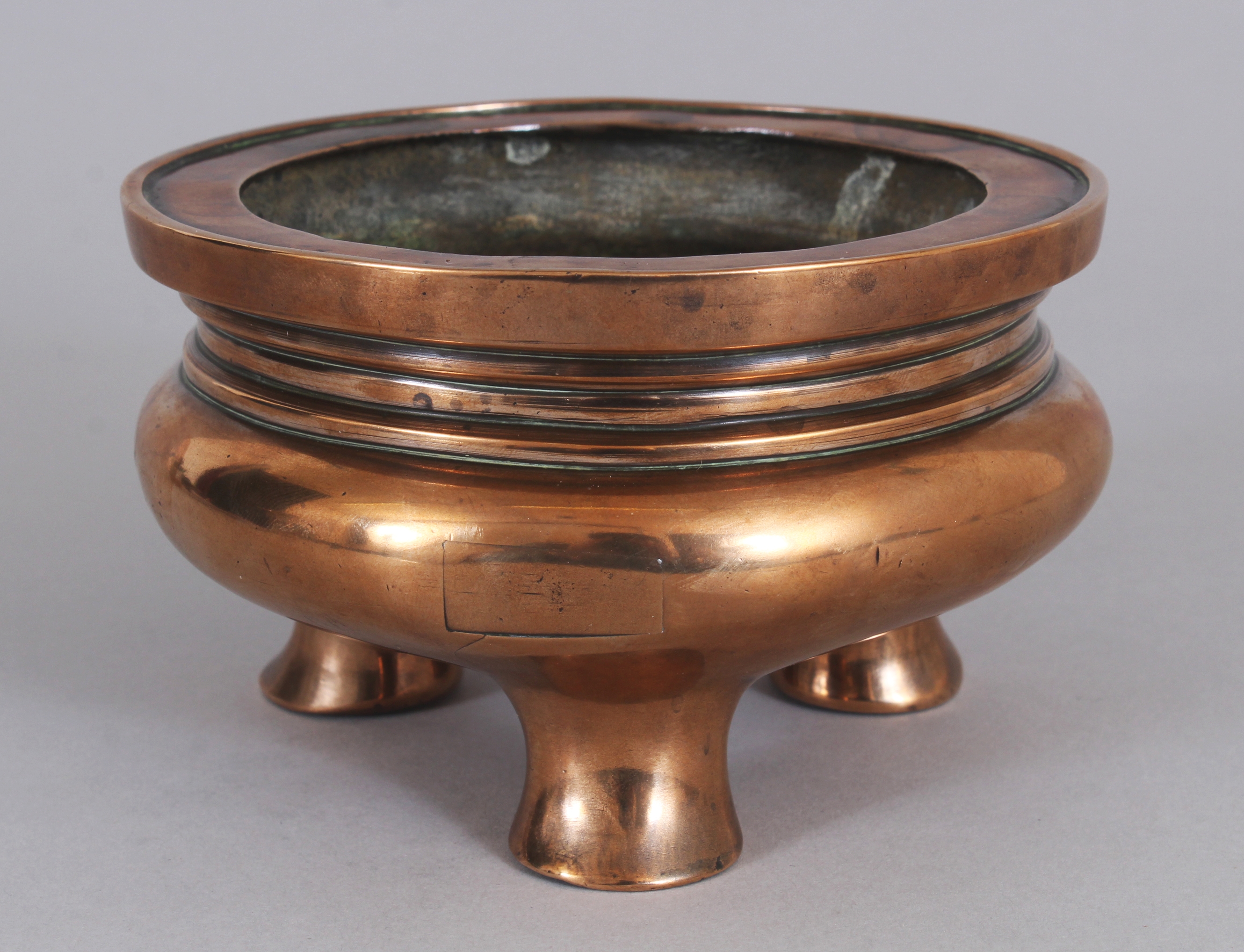 A GOOD 17TH/18TH CENTURY CHINESE POLISHED BRONZE TRIPOD CENSER, weighing approx. 905gm, the base