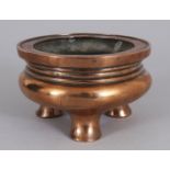 A GOOD 17TH/18TH CENTURY CHINESE POLISHED BRONZE TRIPOD CENSER, weighing approx. 905gm, the base