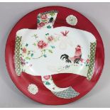 A GOOD QUALITY YONGZHENG STYLE FAMILLE ROSE RUBY GROUND PORCELAIN PLATE, decorated with a scroll-