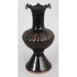 A CHINESE SONG STYLE BLACK GLAZED PORCELAIN VASE, with vertical ribbing and a wavy rim, 11.6in