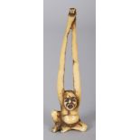 A JAPANESE MEIJI PERIOD STAINED IVORY NETSUKE OF TENAGA, his long arms stretched out above his