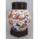 A CHINESE IMARI KANGXI PERIOD PORCELAIN JAR, circa 1700, together with a wood stand and cover, the