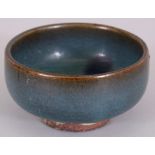 A CHINESE JUN WARE PURPLE SPLASH STONEWARE TEA BOWL, possibly Ming Dynasty, the unglazed base with