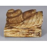 AN EARLY 20TH CENTURY SIGNED JAPANESE STAINED BONE NETSUKE OF A SNAIL, crawling along a leaf above