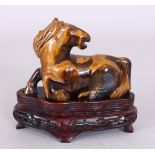 A 20TH CENTURY CHINESE TIGER'S EYE CARVING OF A RECUMBENT HORSE, together with a fitted wood