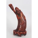 AN EARLY 20TH CENTURY CHINESE HORN CARVING OF SHOU LAO, together with a fixed wood stand, the