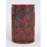 A CHINESE LATE QING DYNASTY BAMBOO BRUSHPOT, carved in deep relief with a continuous mountainous