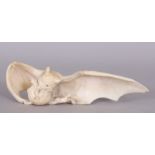 A VERY UNUSUAL FINE QUALITY JAPANESE MEIJI PERIOD IVORY OKIMONO OF A BAT, eating from a pomegranate,