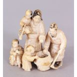 A SIGNED JAPANESE MEIJI PERIOD IVORY OKIMONO OF A FAMILY GROUP, gathered around a cauldron, the base