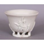 A CHINESE KANGXI PERIOD BLANC-DE-CHINE PORCELAIN LIBATION CUP, circa 1700, the sides moulded with