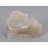 A CHINESE WHITE JADE MODEL OF A RECUMBENT DEER, its head turned backwards along its body, 2.2in long