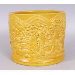 A LARGE CHINESE YELLOW GLAZED MOULDED PORCELAIN BRUSHPOT, the sides decorated with a continuous