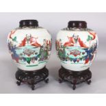 A PAIR OF CHINESE FAMILLE VERTE PORCELAIN JARS & COVERS, with good quality fitted wood stands and