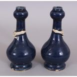 A GOOD PAIR OF 16TH/17TH CENTURY CHINESE BLUE GLAZED PORCELAIN BOTTLE VASES, with garlic necks, each