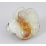 A 19TH/20TH CENTURY CHINESE CELADON JADE CARVING OF A LOTUS POD, the stone with russet inclusions,