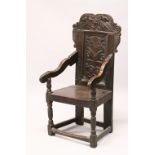 A 17TH-18TH CENTURY OAK WAINSCOT CHAIR, with carved back, solid seat and curving arms.