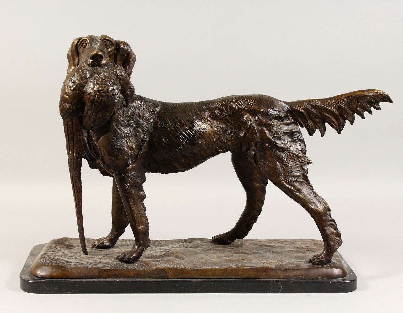 AFTER MOIGNIEZ A LARGE BRONZE OF A RETRIEVER, with a pheasant in its mouth, standing on a marble