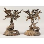 A GOOD PAIR OF VICTORIAN CAST PLATED STANDS, the bases with rabbits.