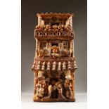 A PERUVIAN PAINTED POTTERY THREE STOREY HOUSE, with figures on all levels. 51cms high x 22cms wide.