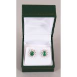 A PAIR OF 9CT GOLD, EMERALD AND DIAMOND CLUSTER EARRINGS.