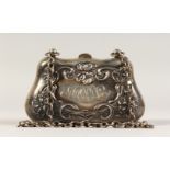 AN EDWARDIAN SILVER PURSE on a chain.