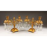 A GOOD PAIR OF REGENCY TWO-LIGHT CANDELABRA, with scrolling branches, prism drops, on square