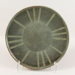 A CREAM POTTERY CIRCULAR DISH with sun ray pattern. 15ins diameter.
