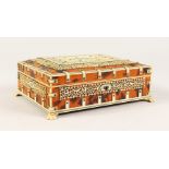 AN ISLAMIC TORTOISESHELL AND IVORY JEWELLERY BOX, with velvet interior, on claw feet. 7.5ins.