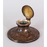 A CIRCULAR CAPSTAN INKSTAND. 4.75ins diameter. London 1900.