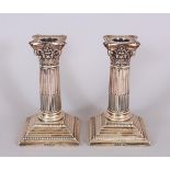 A PAIR OF VICTORIAN CORINTHIAN COLUMN CANDLESTICKS, on stepped bases. 6ins high. Sheffield 1898.
