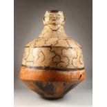 A GOOD PERUVIAN SHIPIBO CULTURE CIRCULAR POT, the top with two faces. 69cms high x 50cms diameter.