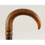 A RHINO HORN HANDLED CONTINENTAL WALKING STICK. 2ft 10ins long.