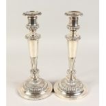 A GOOD PAIR OF GEORGE III CIRCULAR CANDLESTICKS, with wooden bases. 12ins high. Sheffield 1811.