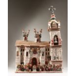 A SUPERB LARGE PERUVIAN PAINTED POTTERY CHURCH, the bell tower with bell and numerous figures. 77cms