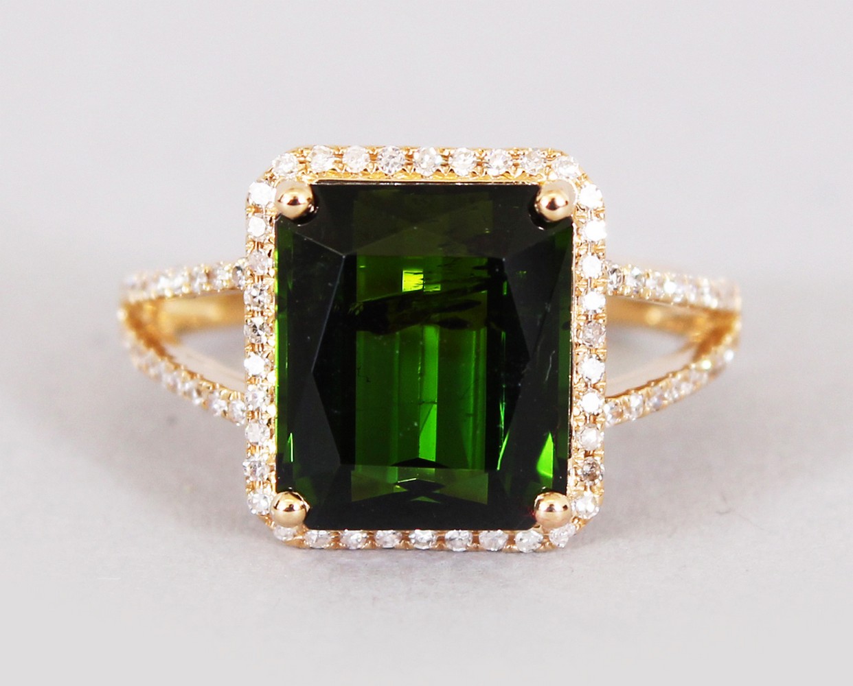 A 14CT YELLOW GOLD AND DIAMOND RING set with an emerald cut green tourmaline approx. 5.19cts.