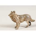 A CAST SILVER MODEL OF A DOG. 6.5cms long.