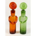 AN UNUSUAL PAIR OF GLASS BOTTLES, modelled as standing figures. 10ins high.