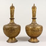 A PAIR OF INDIAN BRASS BOTTLE VASES AND COVERS. 16ins high.