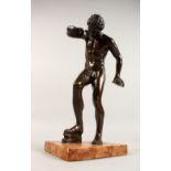 AFTER THE ANTIQUE. A BRONZE DISCUS THROWER on a marble base. 12ins high.