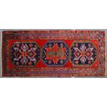A GOOD CAUCASIAN CARPET, red ground with three large medallions, with stylised decoration, in a