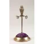 A SILVER OWL STAND, with blue velvet and tortoiseshell base. 13cms high. London 1908.